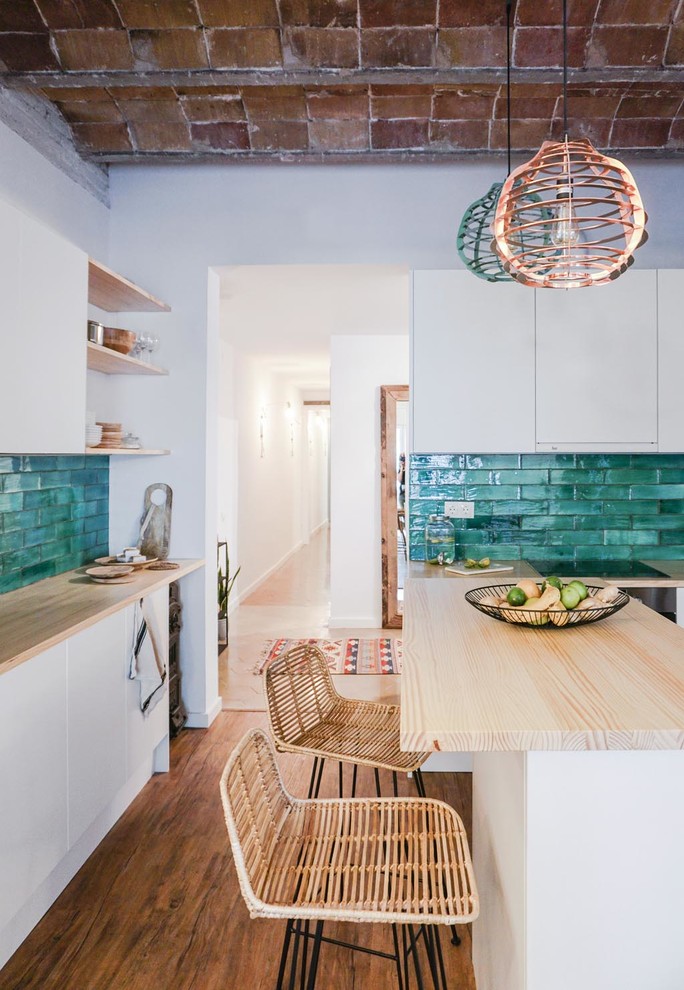 Inspiration for a mid-sized mediterranean l-shaped open plan kitchen in Barcelona with recessed-panel cabinets, white cabinets, wood benchtops, green splashback, ceramic splashback, medium hardwood floors and with island.