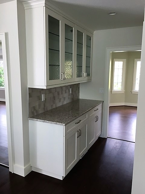 Example of a large transitional dark wood floor and brown floor open concept kitchen design in Seattle with an undermount sink, shaker cabinets, white cabinets, quartz countertops, multicolored backsplash, glass tile backsplash, stainless steel appliances and an island