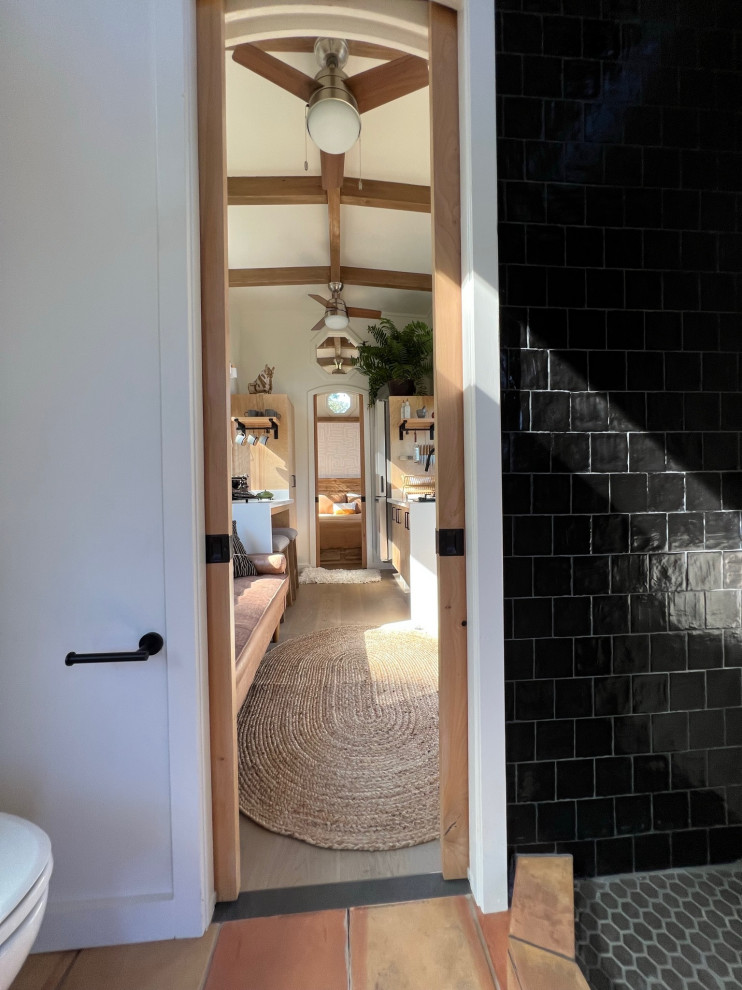 Inspiration for a mid-sized country master bathroom in Hawaii with open cabinets, light wood cabinets, a corner shower, black and white tile, ceramic tile, terra-cotta floors, wood benchtops, a shower curtain, beige benchtops, a niche, a single vanity, a floating vanity and exposed beam.