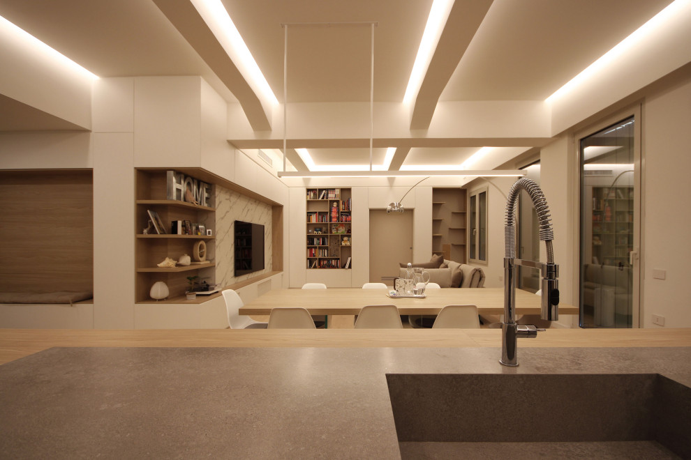 Modelo de sala de estar con biblioteca tipo loft escandinava grande con paredes blancas, suelo de madera en tonos medios, pared multimedia, suelo marrón, bandeja y panelado