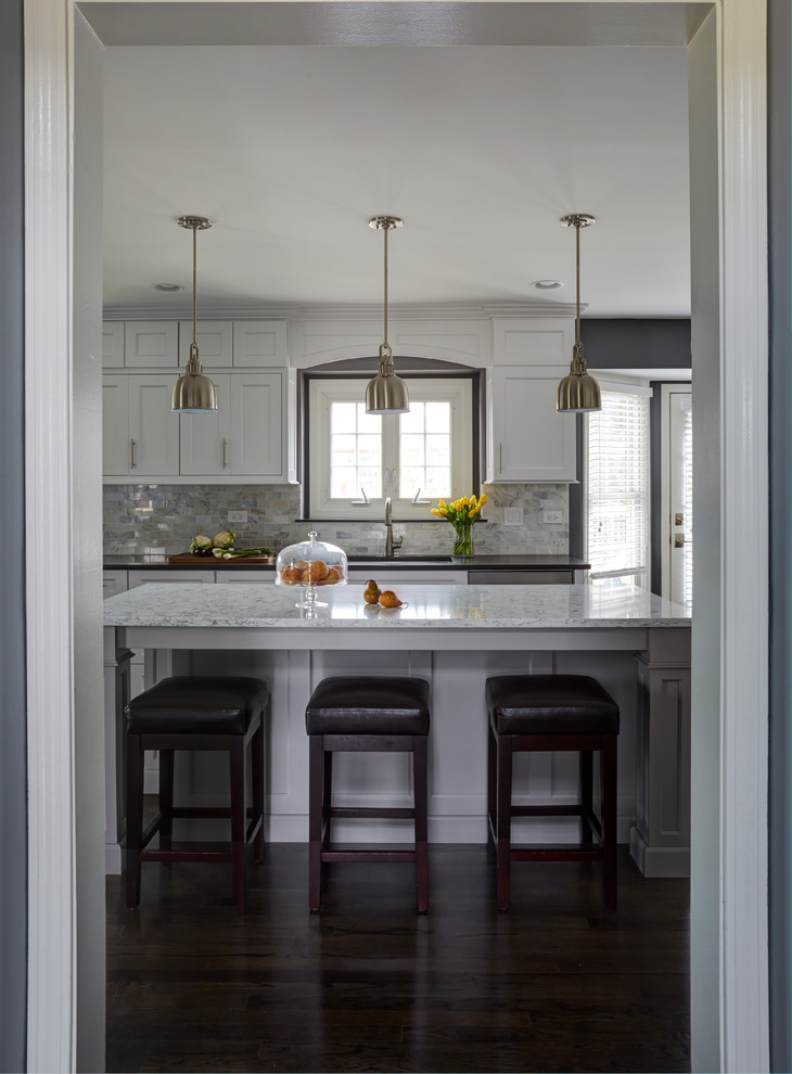 Large transitional dark wood floor kitchen photo in Chicago with a single-bowl sink, shaker cabinets, white cabinets, quartz countertops, white backsplash, stone tile backsplash, stainless steel appliances and two islands