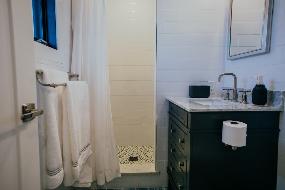 This is an example of a small transitional 3/4 bathroom in Denver with shaker cabinets, dark wood cabinets, an alcove shower, a one-piece toilet, white tile, ceramic tile, grey walls, cement tiles, an undermount sink, marble benchtops, blue floor, a shower curtain and white benchtops.