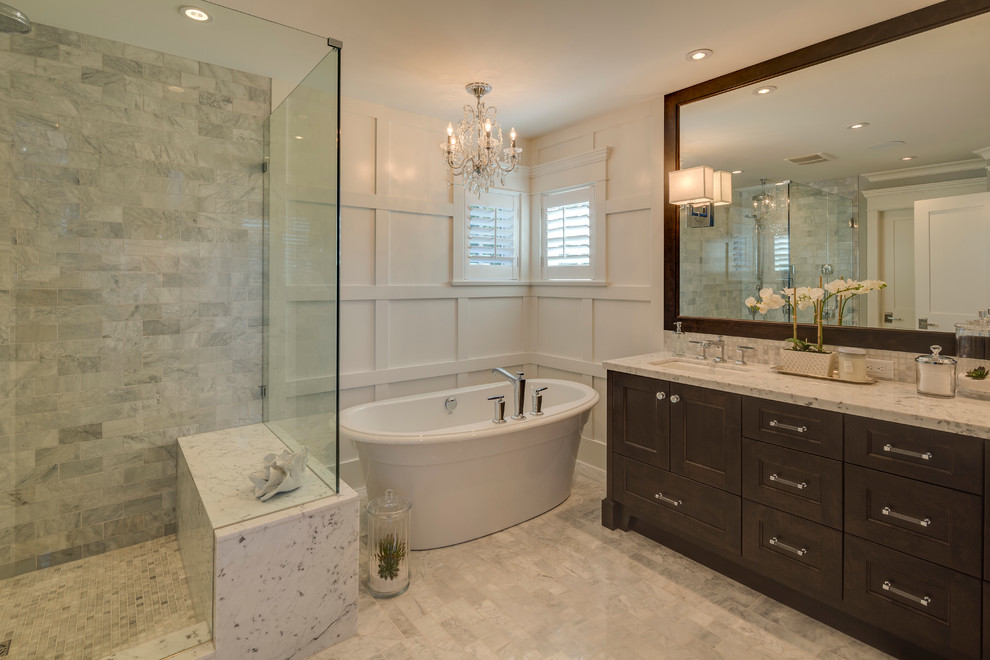 Mid-sized traditional master bathroom in Vancouver with an undermount sink, recessed-panel cabinets, dark wood cabinets, granite benchtops, a freestanding tub, a corner shower, gray tile, porcelain tile, white walls and ceramic floors.