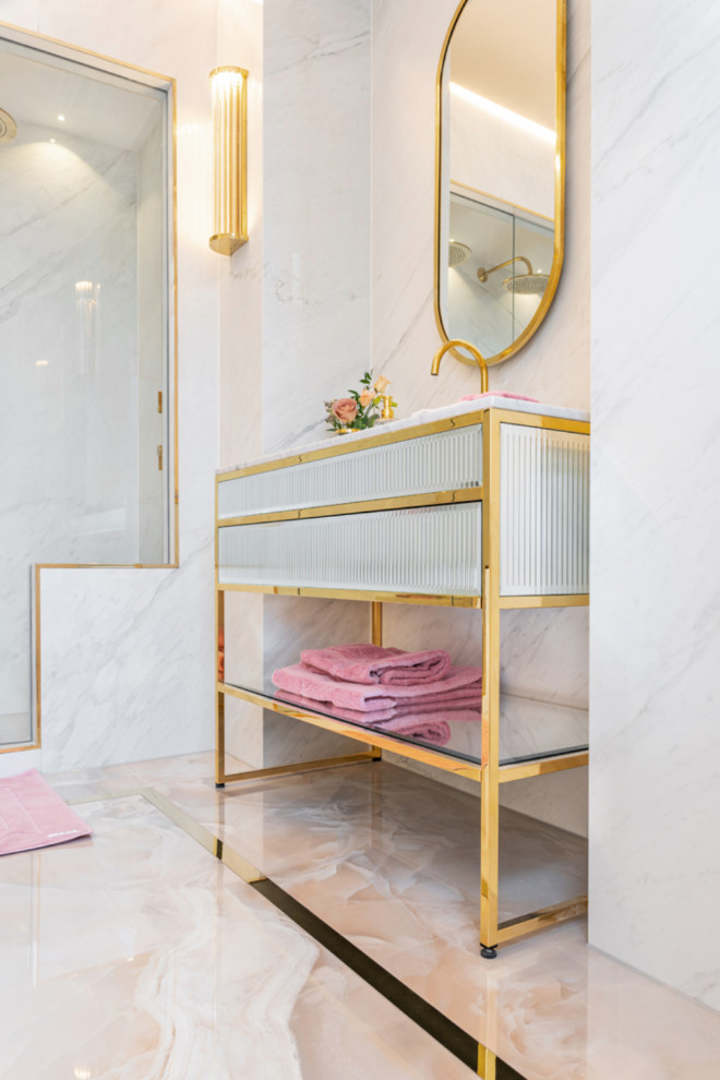 Inredning av ett modernt stort vit vitt en-suite badrum, med luckor med glaspanel, vita skåp, en dusch/badkar-kombination, en vägghängd toalettstol, vit kakel, keramikplattor, vita väggar, klinkergolv i keramik, ett integrerad handfat, marmorbänkskiva, rosa golv och dusch med gångjärnsdörr