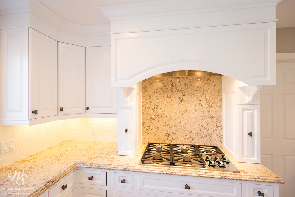 Mid-sized transitional u-shaped porcelain tile eat-in kitchen photo in Toronto with an undermount sink, raised-panel cabinets, white cabinets, quartzite countertops, beige backsplash, stone slab backsplash, stainless steel appliances and an island