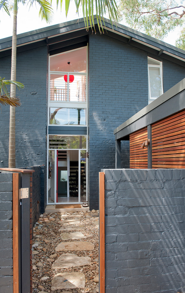 Mid-sized contemporary three-storey brick grey exterior in Sydney with a gable roof.