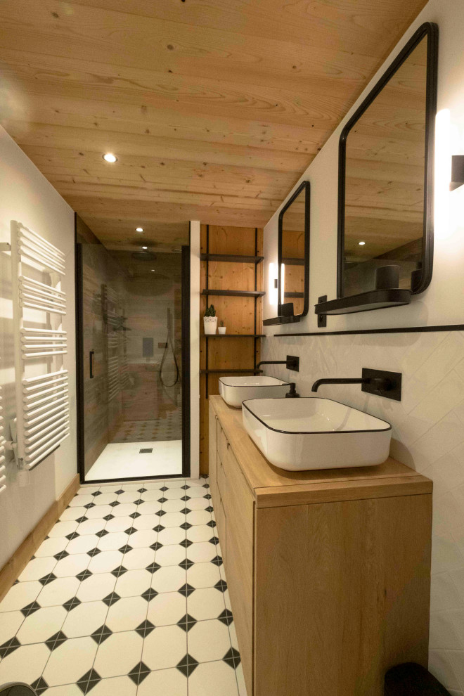 Photo of a small country 3/4 bathroom in Lyon with a curbless shower, brown tile, wood-look tile, white walls, cement tiles, a console sink, wood benchtops, white floor, a hinged shower door, brown benchtops, a double vanity, a freestanding vanity and wood.