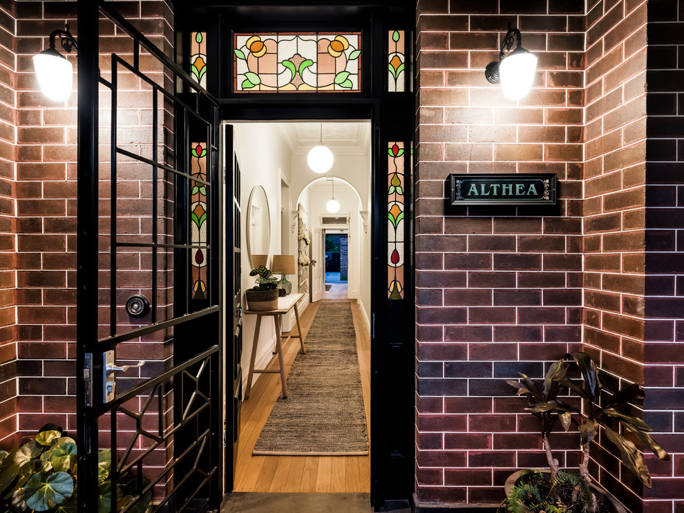 Inspiration for a mid-sized contemporary front door in Sydney with brown walls, ceramic floors, a single front door, a black front door and multi-coloured floor.
