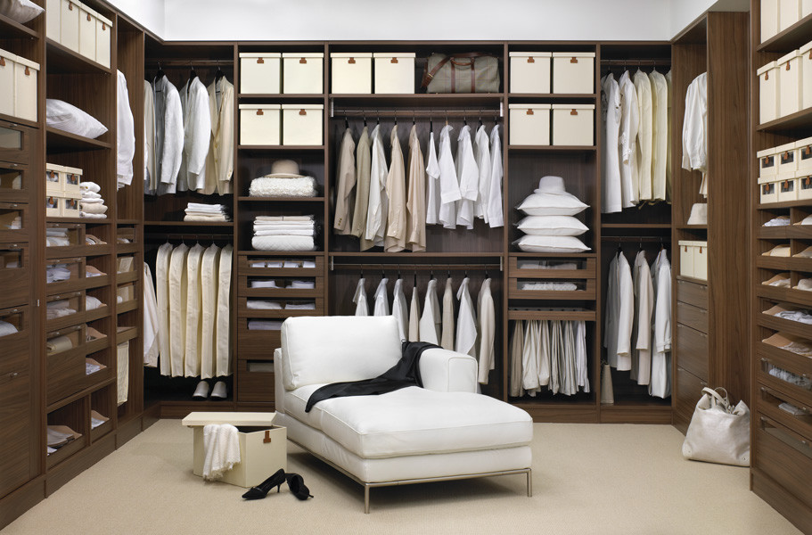 This is an example of a large contemporary gender-neutral walk-in wardrobe in Montreal with flat-panel cabinets, carpet and brown cabinets.