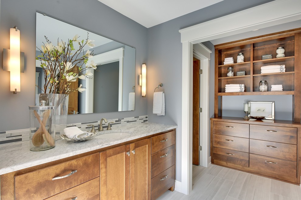 Design ideas for a transitional bathroom in Minneapolis with flat-panel cabinets, medium wood cabinets, grey walls, an undermount sink, grey floor and grey benchtops.