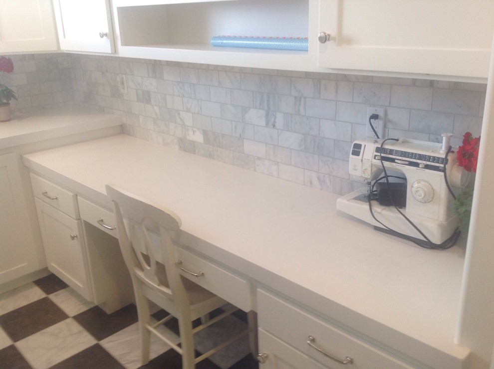 This is an example of a large arts and crafts laundry room in Salt Lake City with shaker cabinets, white cabinets, an undermount sink, quartzite benchtops, porcelain floors and a stacked washer and dryer.