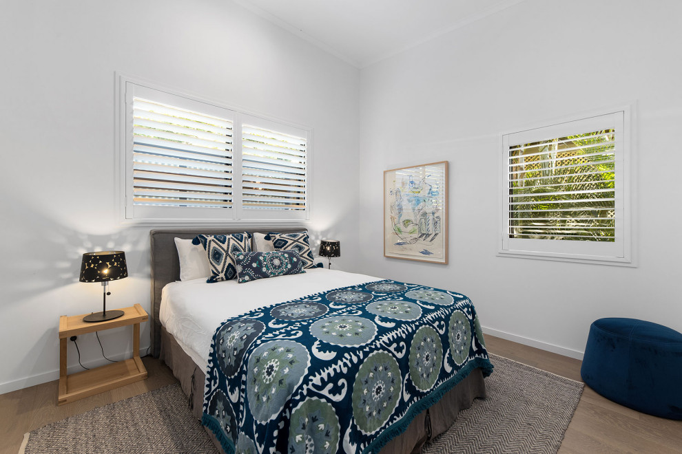 Kleines Maritimes Gästezimmer mit weißer Wandfarbe, hellem Holzboden, braunem Boden, gewölbter Decke und vertäfelten Wänden in Sunshine Coast