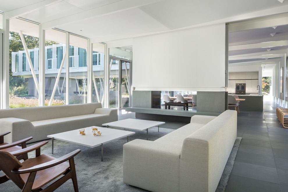 Example of a large minimalist open concept living room design in New York with a two-sided fireplace