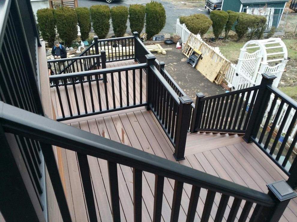 Inspiration for a huge rustic backyard balcony deck remodel in New York with a roof extension