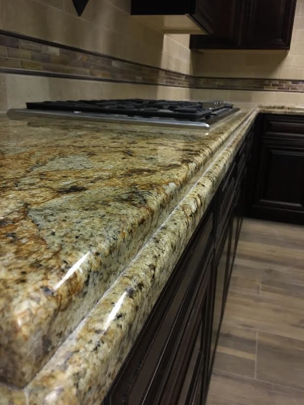 Enclosed kitchen - mid-sized transitional l-shaped porcelain tile enclosed kitchen idea in Austin with raised-panel cabinets, dark wood cabinets, granite countertops, beige backsplash, stone tile backsplash, stainless steel appliances and no island