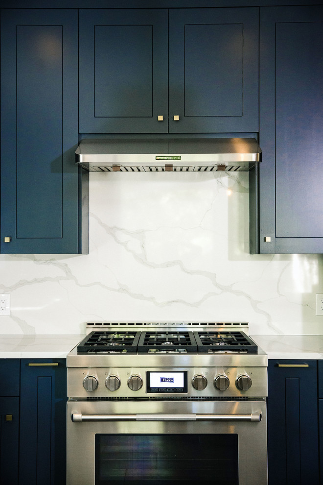 Example of a mid-sized transitional l-shaped cement tile floor and gray floor eat-in kitchen design in Austin with an undermount sink, flat-panel cabinets, blue cabinets, quartz countertops, white backsplash, stainless steel appliances, an island and white countertops