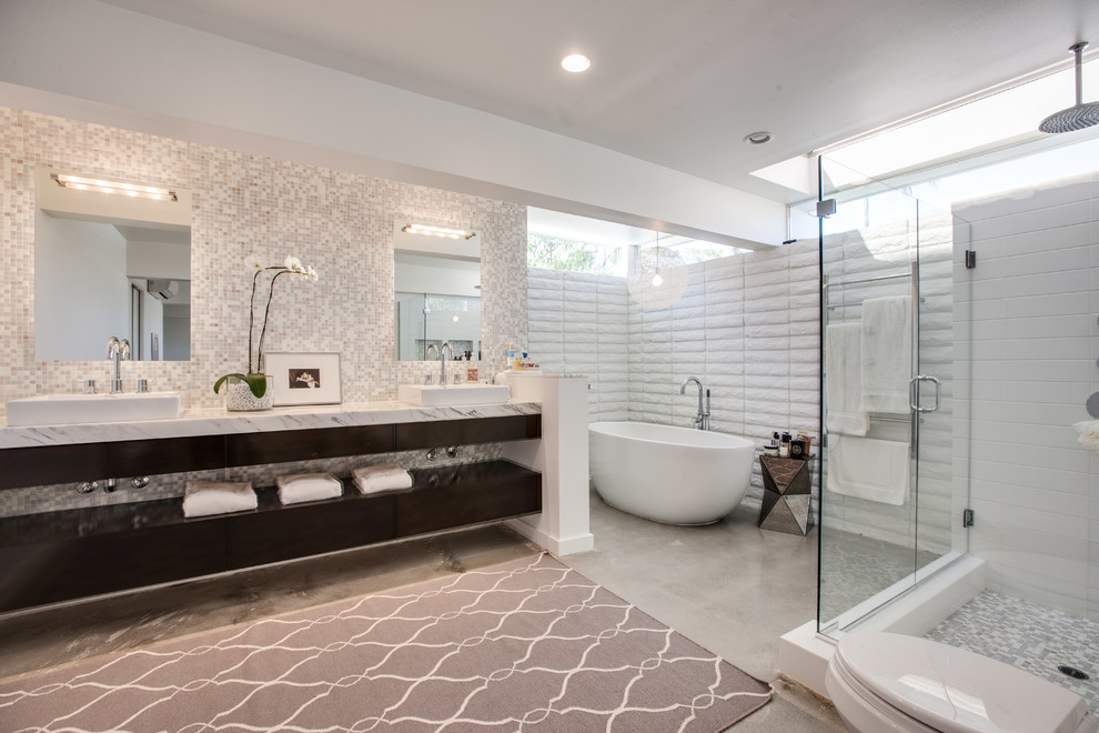 Large midcentury master bathroom in Orange County with a freestanding tub, open cabinets, a corner shower, white tile, concrete floors, a vessel sink, marble benchtops, grey floor and a hinged shower door.