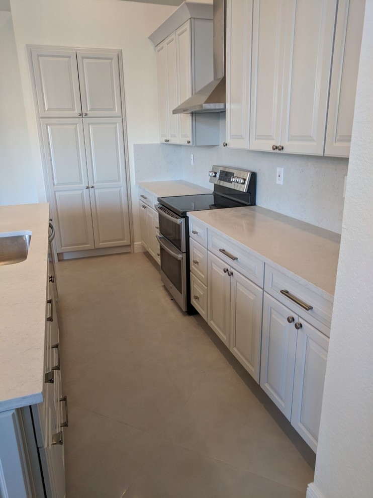 Inspiration for a mid-sized transitional u-shaped porcelain tile and gray floor eat-in kitchen remodel in Miami with an undermount sink, shaker cabinets, beige cabinets, quartz countertops, white backsplash, stone slab backsplash, stainless steel appliances, an island and white countertops