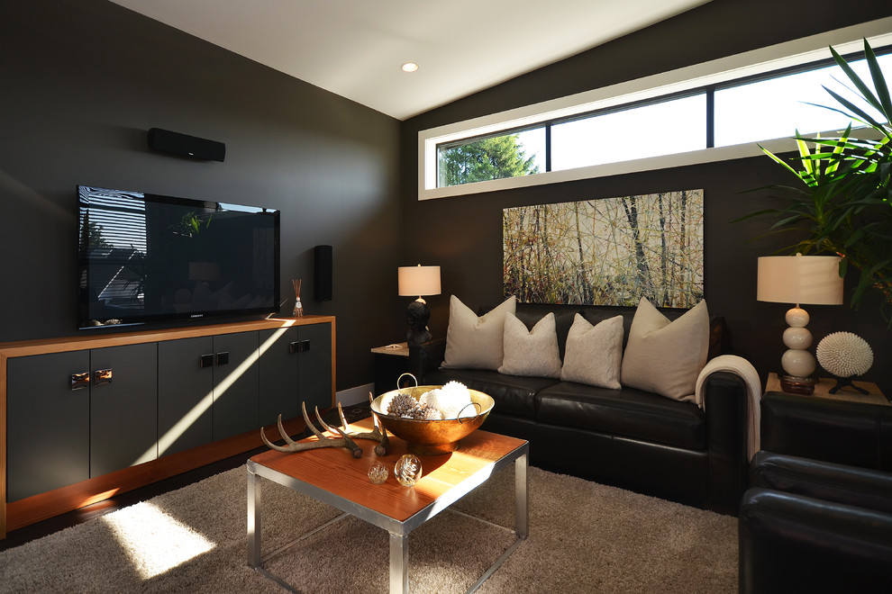 Photo of a contemporary family room in Vancouver with black walls and a freestanding tv.