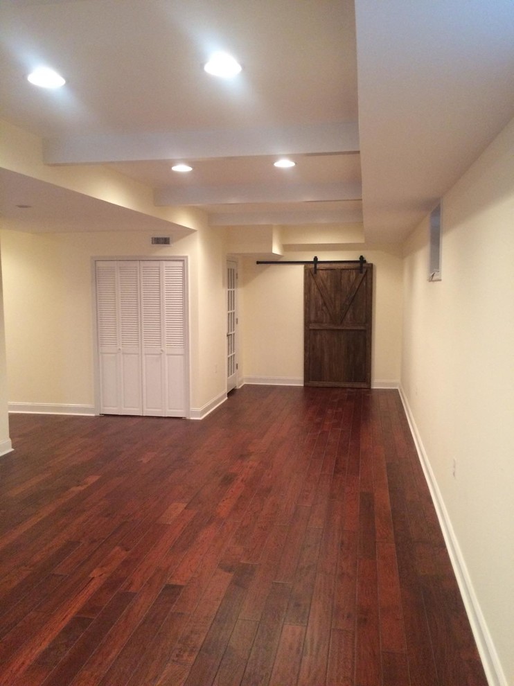 Basement - large rustic walk-out dark wood floor and brown floor basement idea in DC Metro with beige walls and no fireplace