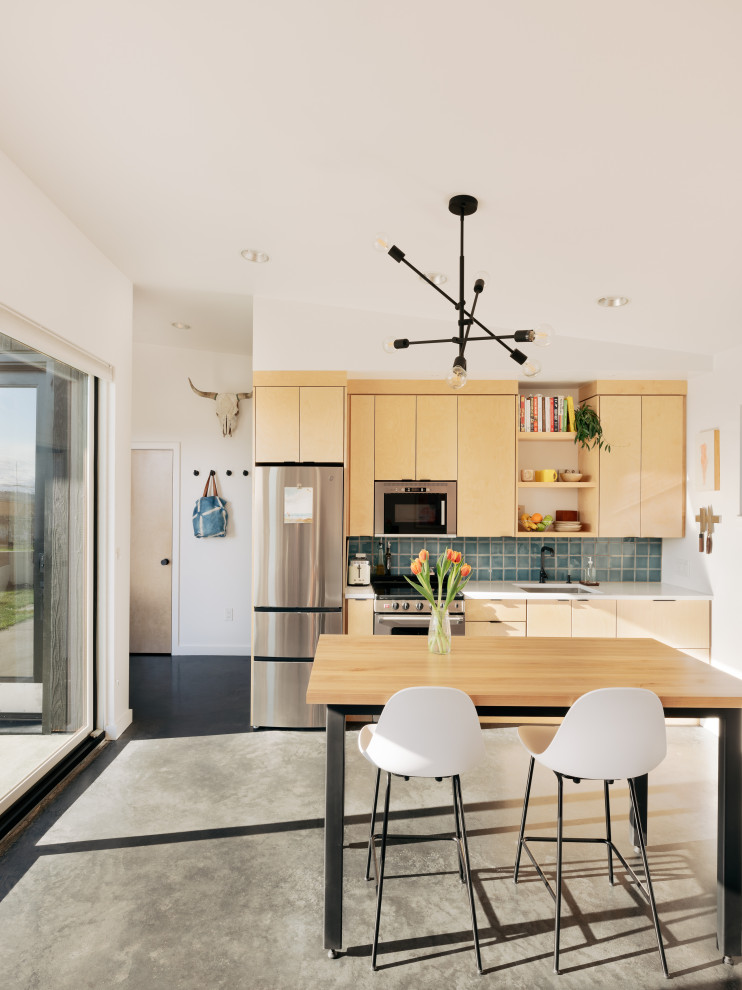 Example of a trendy concrete floor open concept kitchen design in Seattle with an undermount sink, flat-panel cabinets, light wood cabinets, blue backsplash and ceramic backsplash