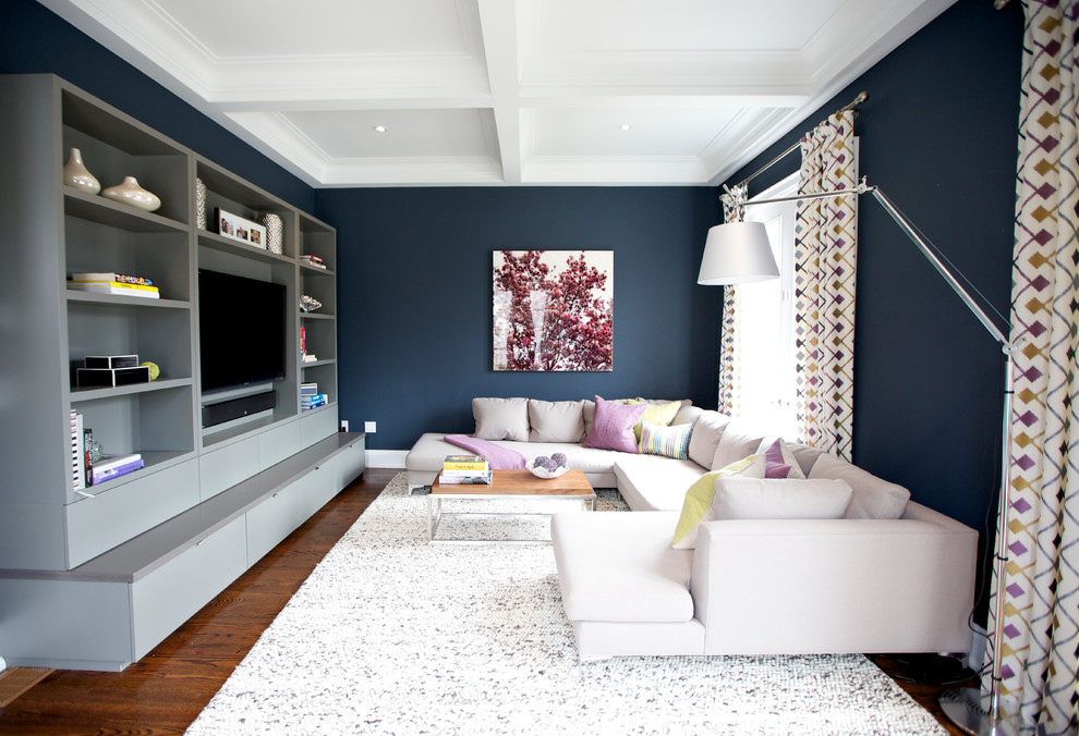 Contemporary family room in Toronto with blue walls, dark hardwood floors and a built-in media wall.