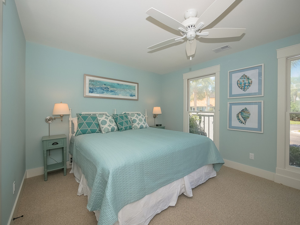 This is an example of a mid-sized beach style guest bedroom in Other with blue walls, carpet and beige floor.
