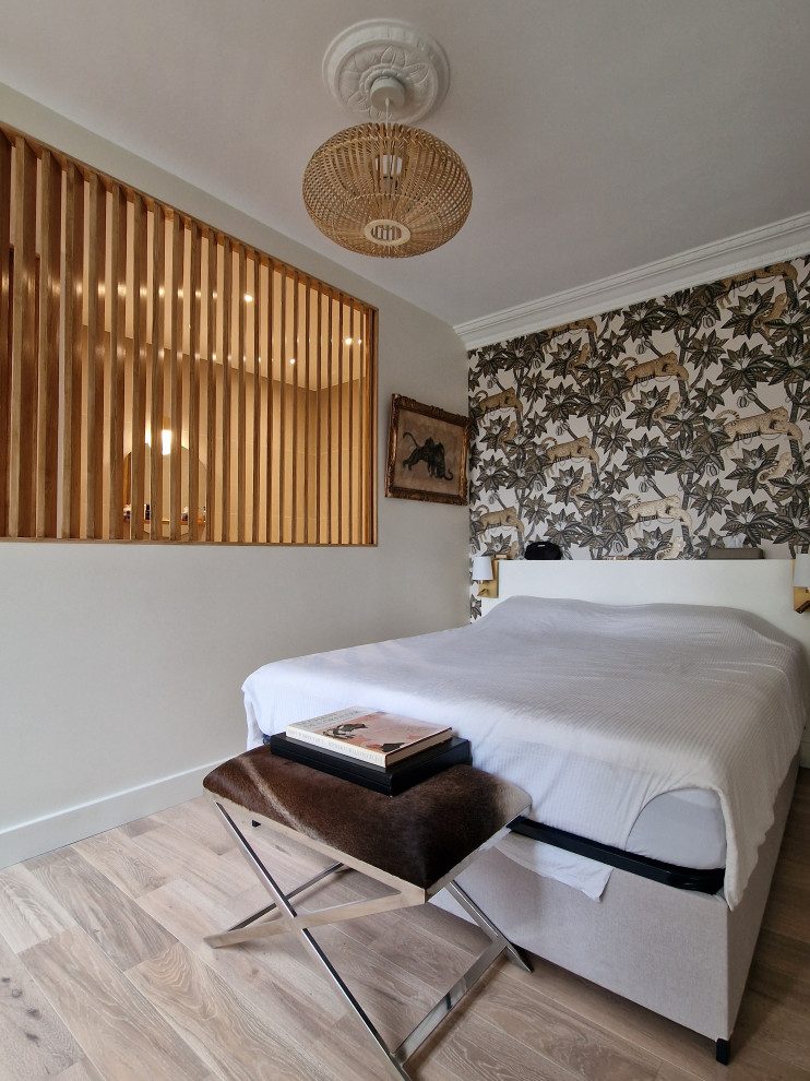 Imagen de dormitorio principal y beige y blanco clásico renovado de tamaño medio sin chimenea con paredes beige, suelo laminado, suelo beige y papel pintado