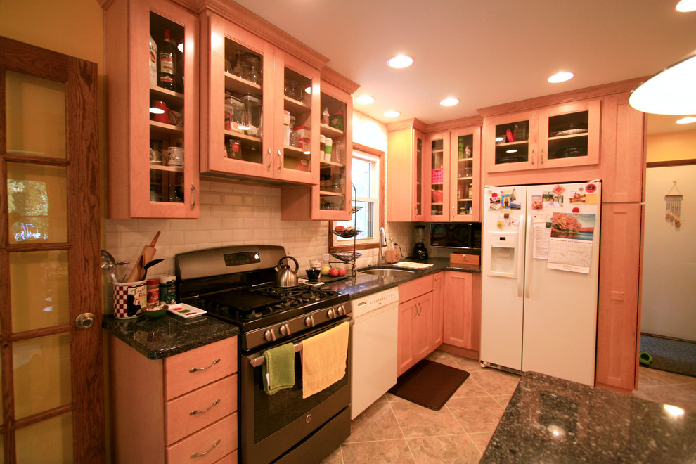 Eat-in kitchen - small transitional eat-in kitchen idea with an undermount sink, recessed-panel cabinets, light wood cabinets, quartz countertops, white backsplash, subway tile backsplash, white appliances and a peninsula