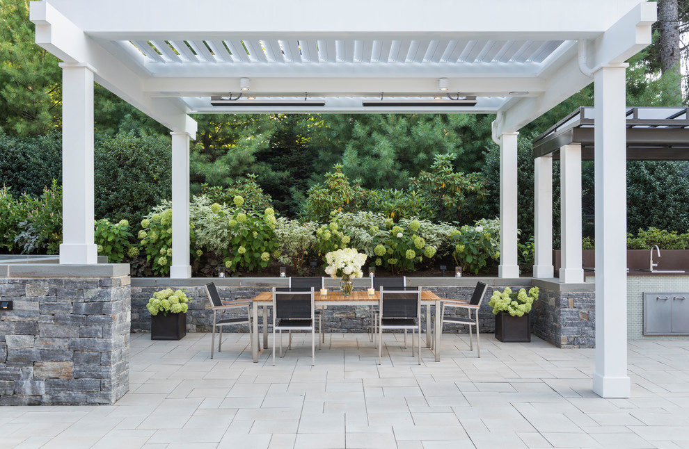 Design ideas for a transitional backyard patio in Boston with a container garden, concrete pavers and a pergola.