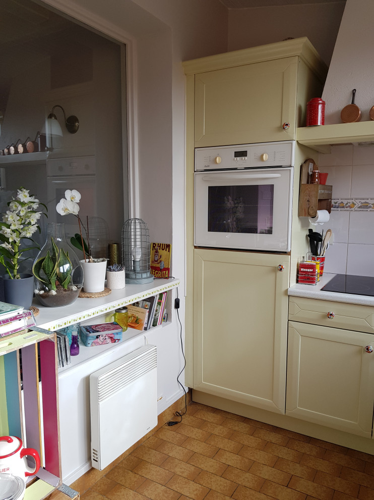 Aménagement d'une cuisine campagne fermée et de taille moyenne avec un évier encastré, un placard à porte plane, des portes de placards vertess, une crédence blanche, une crédence en céramique, un électroménager blanc, un sol en carrelage de céramique, aucun îlot, un sol marron, un plan de travail blanc et un plafond en lambris de bois.