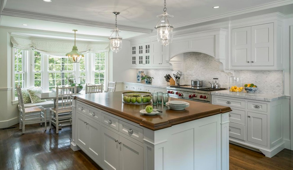 This is an example of a large traditional single-wall eat-in kitchen in Boston with shaker cabinets, white cabinets, marble benchtops, grey splashback, ceramic splashback, stainless steel appliances, dark hardwood floors and with island.