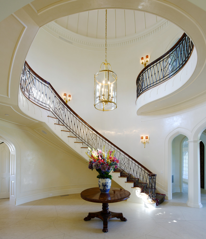 Photo of an expansive traditional wood curved staircase in New York.