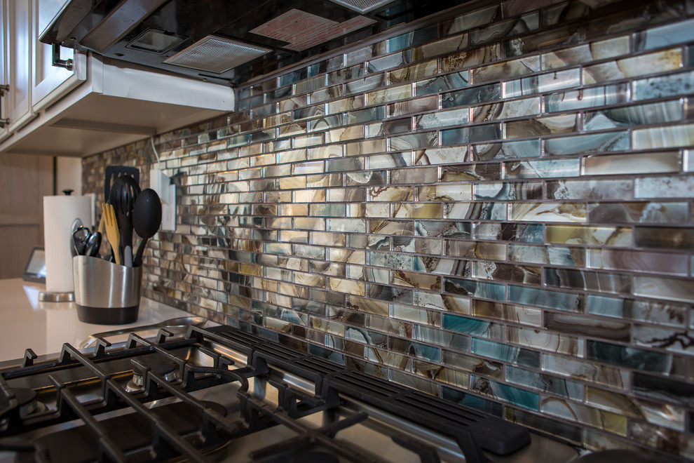 Example of a mid-sized transitional l-shaped dark wood floor and brown floor open concept kitchen design in Denver with a farmhouse sink, shaker cabinets, white cabinets, marble countertops, metallic backsplash, matchstick tile backsplash, paneled appliances, an island and gray countertops