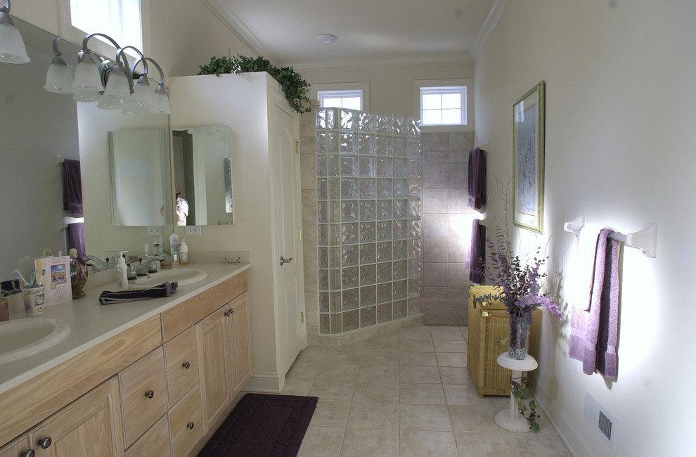 Bild på ett en-suite badrum, med luckor med upphöjd panel, skåp i ljust trä, en jacuzzi, en öppen dusch, en toalettstol med hel cisternkåpa, beige kakel, porslinskakel, beige väggar, ett nedsänkt handfat och bänkskiva i akrylsten
