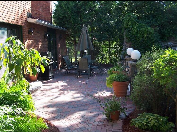 Photo of a mid-sized traditional backyard patio in Toronto with natural stone pavers and no cover.