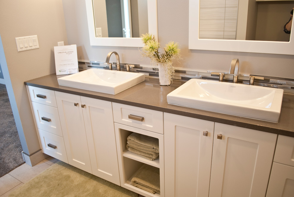 Inspiration for a transitional u-shaped kitchen remodel with an undermount sink, recessed-panel cabinets, white cabinets, quartz countertops, gray backsplash, stainless steel appliances and an island