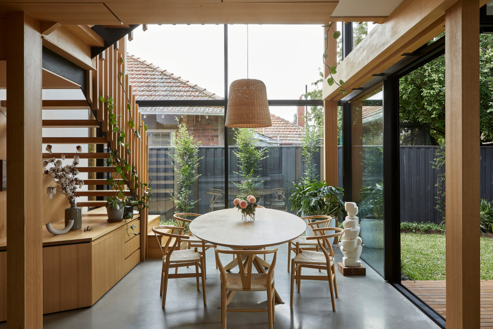 Inspiration for a large contemporary open plan dining in Melbourne with white walls, concrete floors, a wood stove, a brick fireplace surround, grey floor, exposed beam and panelled walls.