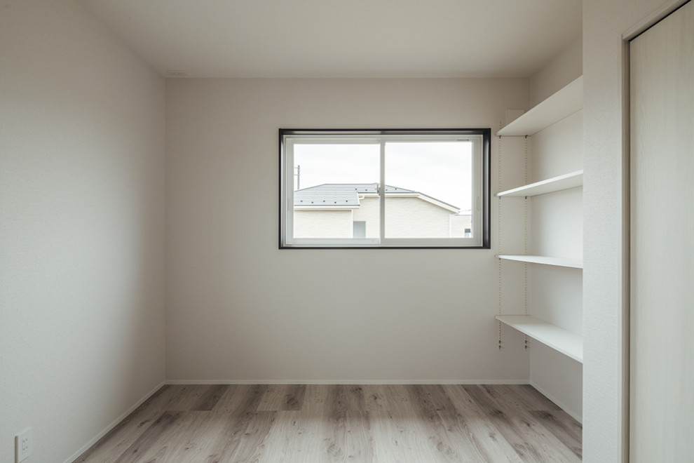 Bild på ett mellanstort könsneutralt barnrum kombinerat med sovrum, med vita väggar och grått golv