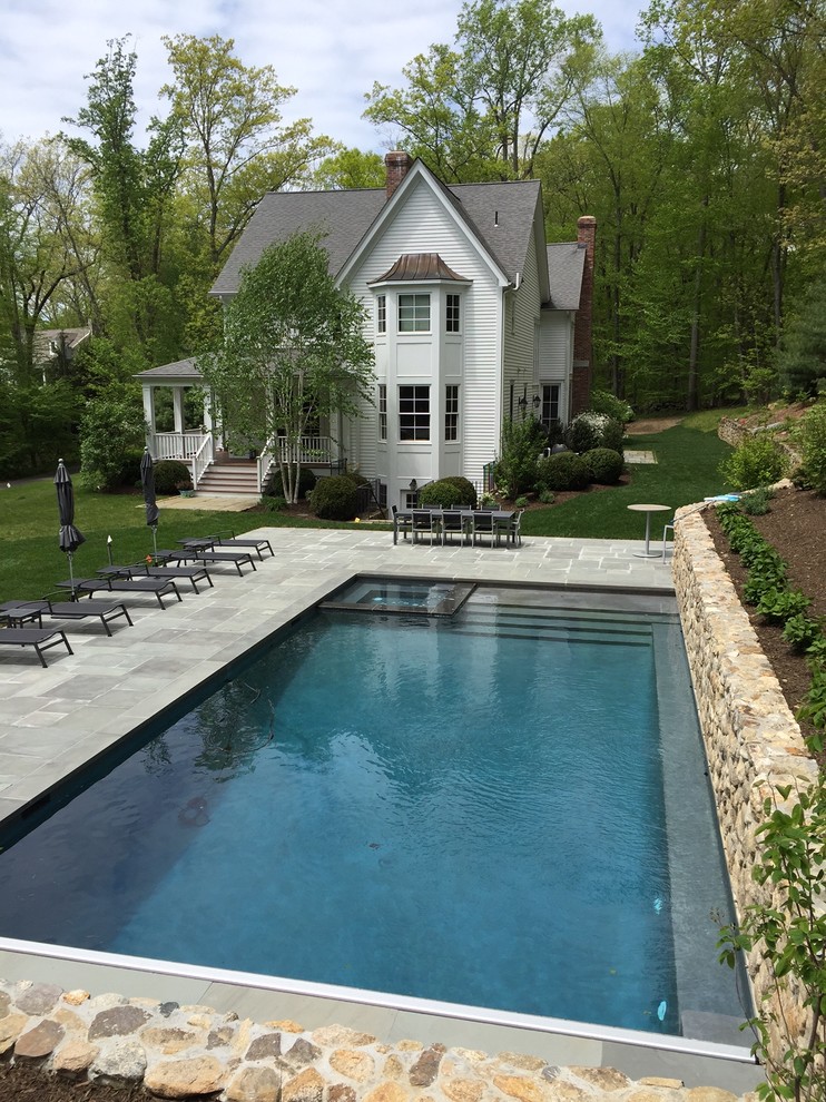 This is an example of a large traditional backyard rectangular pool in New York with a hot tub.