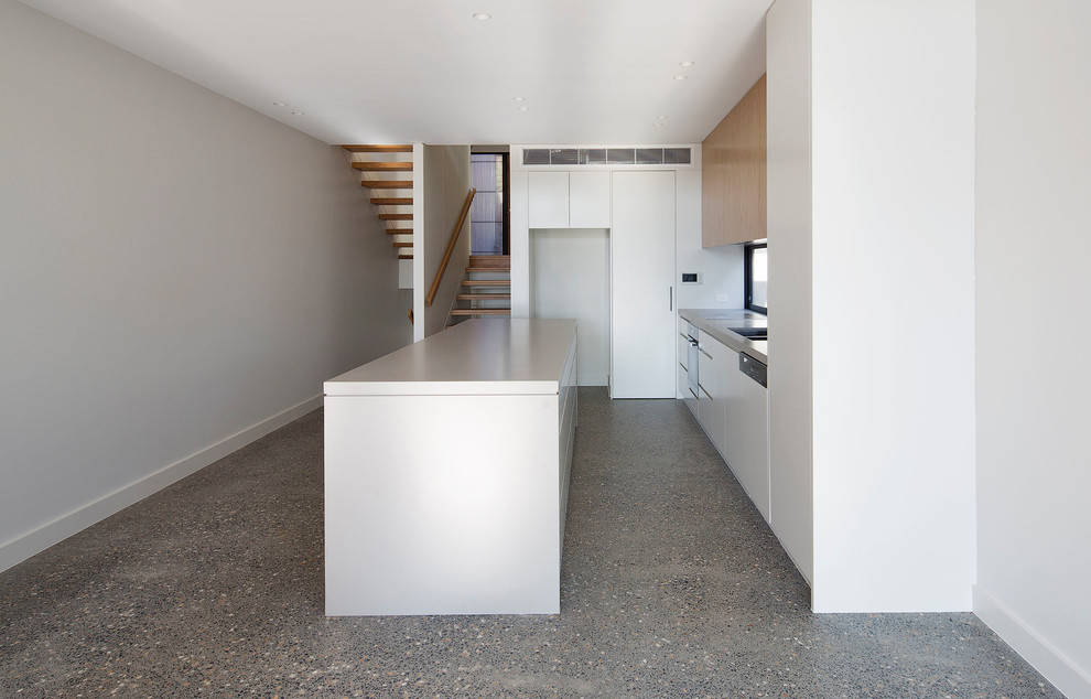 Photo of a mid-sized contemporary galley kitchen pantry in Sydney with flat-panel cabinets, quartz benchtops, concrete floors, with island and beige benchtop.
