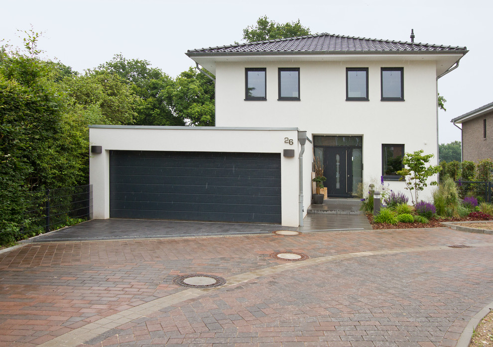 Photo of a mid-sized contemporary two-storey white exterior in Hamburg with a hip roof.