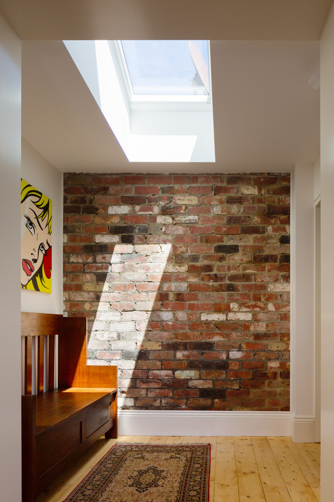 Photo of a contemporary hallway in Melbourne with white walls, light hardwood floors and beige floor.