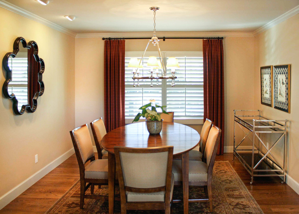 This is an example of a traditional separate dining room in Denver with beige walls and medium hardwood floors.