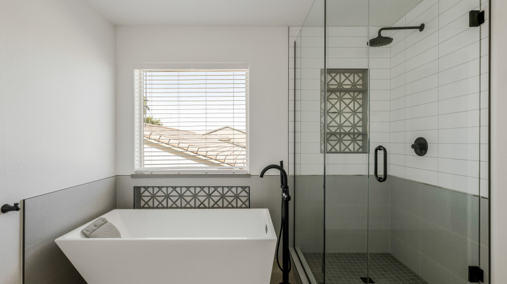 Идея дизайна: большая главная ванная комната в стиле модернизм с отдельно стоящей ванной, душем в нише, разноцветной плиткой, керамогранитной плиткой, белыми стенами, полом из мозаичной плитки, черным полом, душем с распашными дверями и нишей