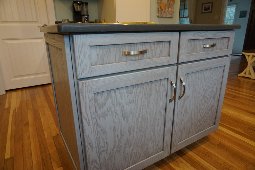 Inspiration for a mid-sized transitional u-shaped medium tone wood floor eat-in kitchen remodel in Boston with an undermount sink, shaker cabinets, gray cabinets, quartz countertops, black backsplash, stainless steel appliances and an island