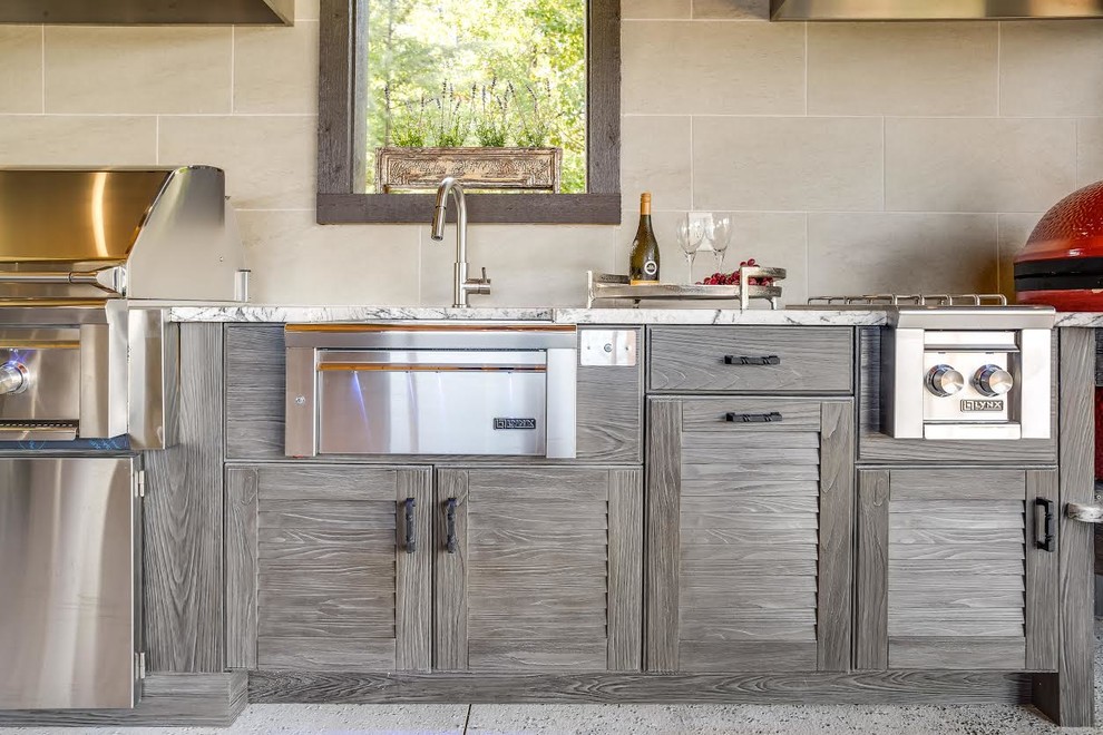 This is an example of an expansive contemporary l-shaped kitchen in Birmingham with a farmhouse sink, louvered cabinets, distressed cabinets, granite benchtops, stainless steel appliances and concrete floors.