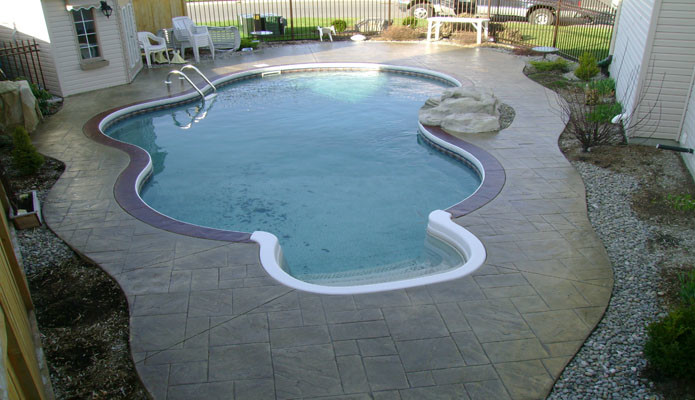 Example of a large classic backyard stone and custom-shaped natural pool design