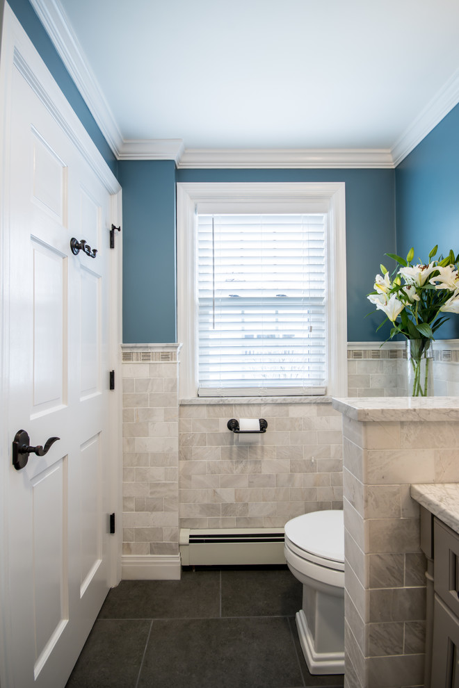Mid-sized traditional 3/4 bathroom in Providence with raised-panel cabinets, grey cabinets, an alcove shower, a two-piece toilet, white tile, subway tile, blue walls, porcelain floors, an undermount sink and marble benchtops.