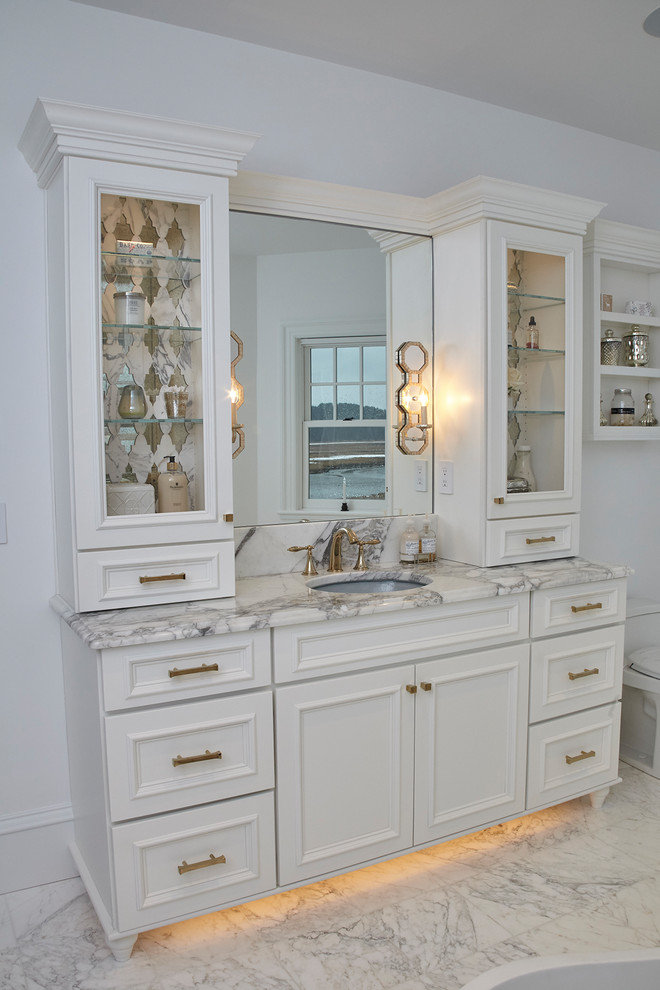 Inspiration for a large transitional kids bathroom in Boston with recessed-panel cabinets, white cabinets, a freestanding tub, an alcove shower, a one-piece toilet, gray tile, marble, white walls, marble floors, an undermount sink, marble benchtops, grey floor and a hinged shower door.